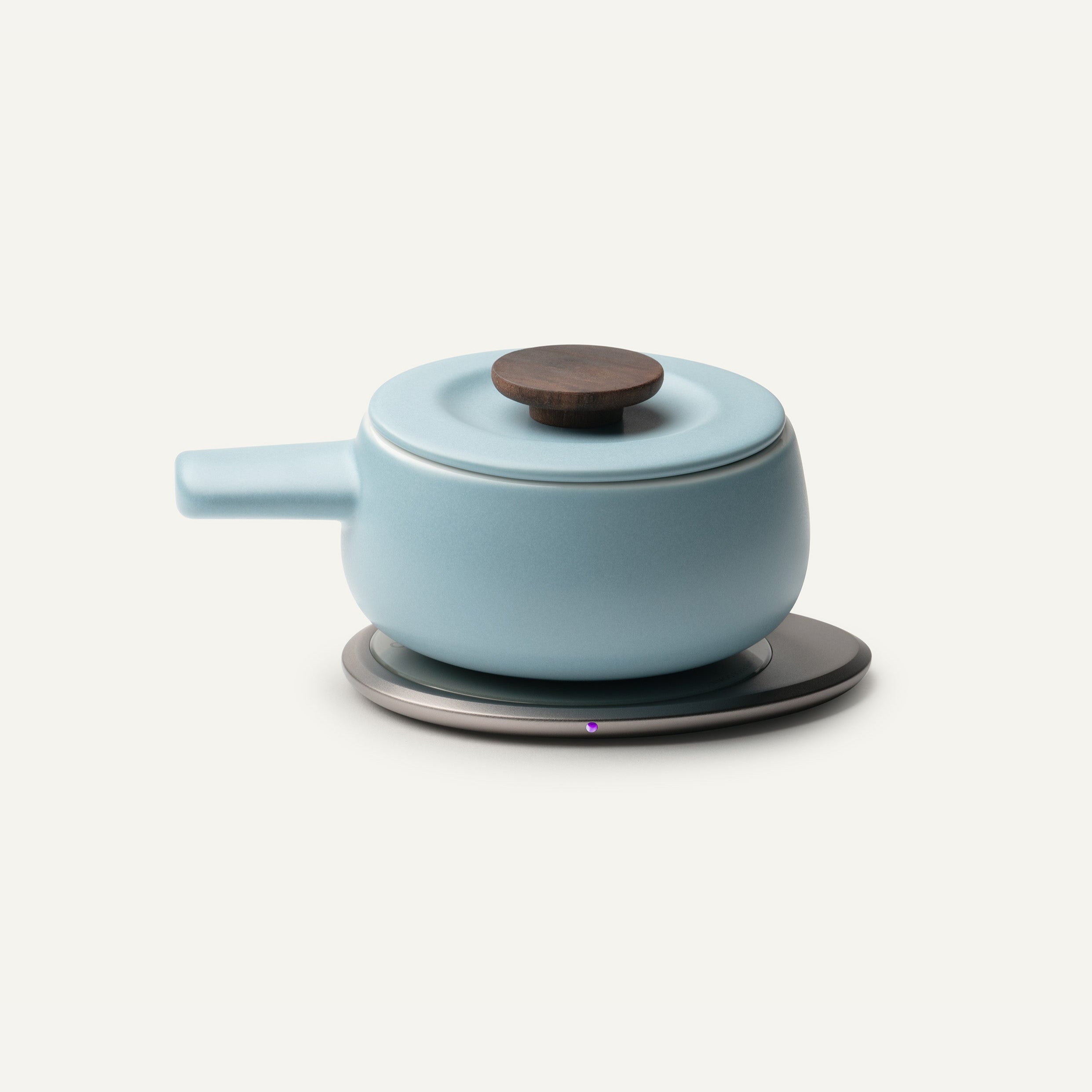 Light blue ceramic pot with a dark brown lid on a white background