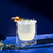Clear glass with a light-colored liquid on a blue background