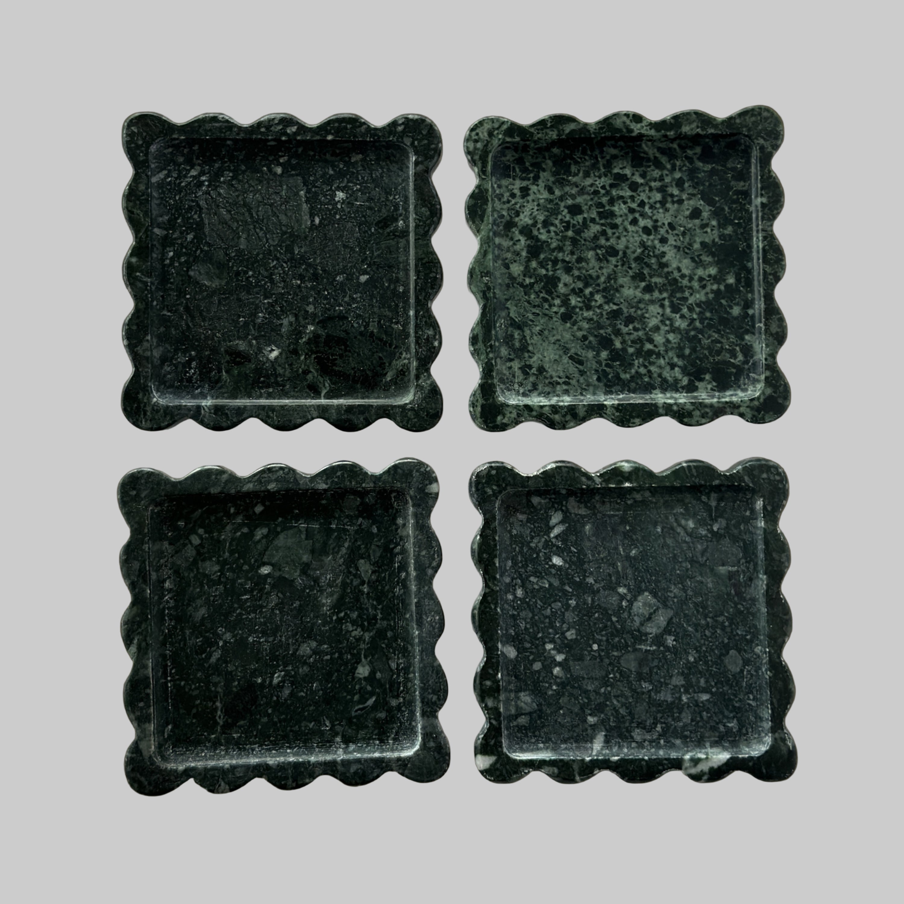 Four dark green square tiles with scalloped edges on a transparent background