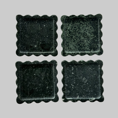 Four dark green square tiles with scalloped edges on a transparent background