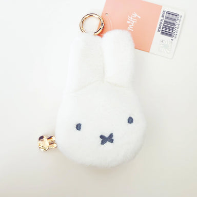 White fluffy keychain with blue accents on a light gray background