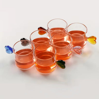 Set of six glass cups with colorful leaf-shaped handles on a white background