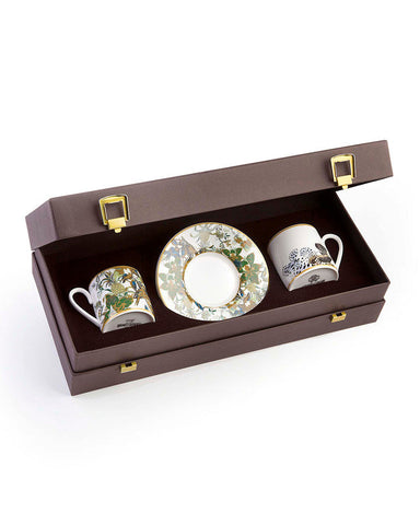 Set of three ceramic cups with decorative patterns in a brown box on a white background