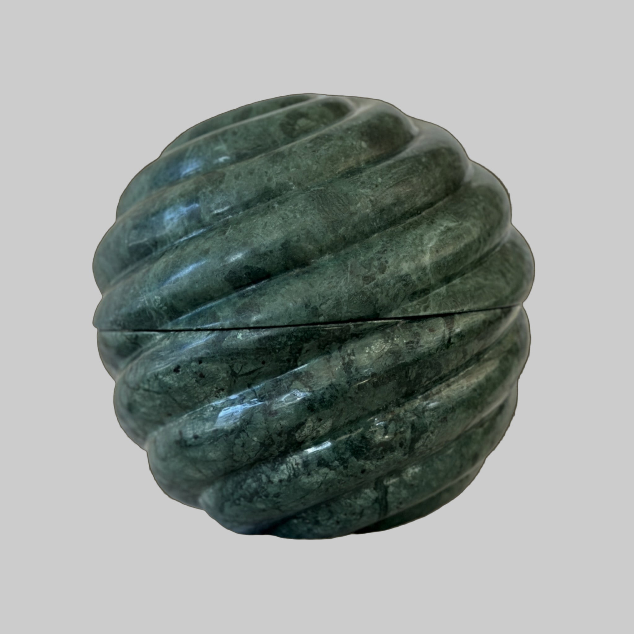 Green marble-like spherical object on a brown background