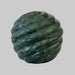 Green marble-like spherical object on a brown background