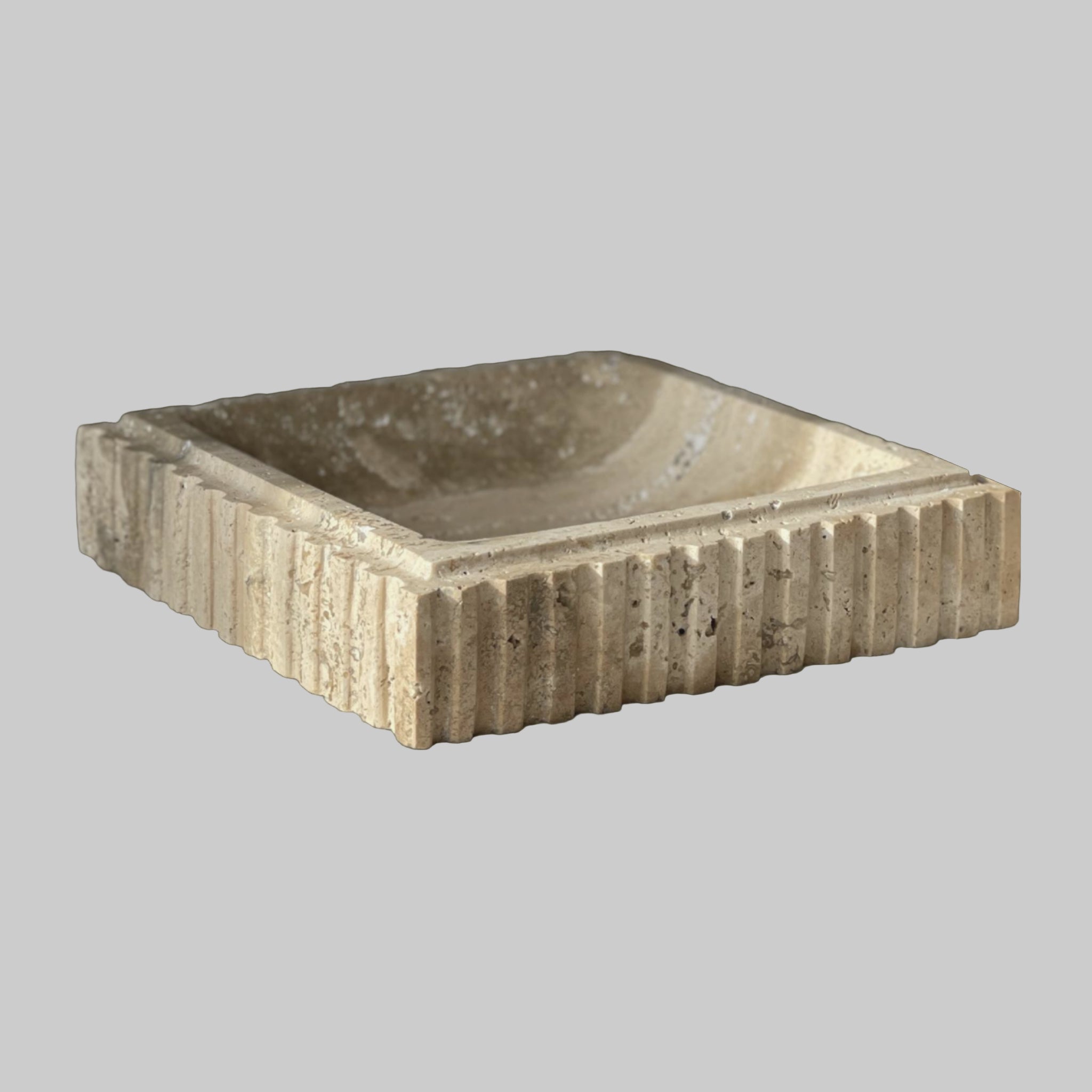 Square stone basin with ribbed texture on a light background
