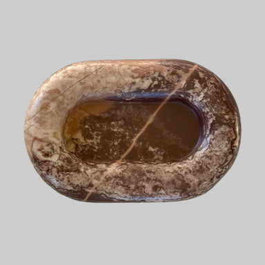 Brown stone with a central hole on a light background
